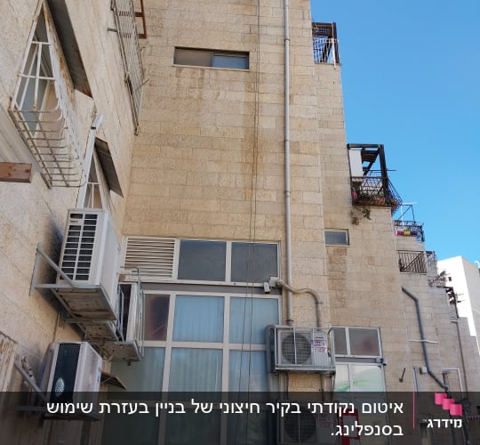 בניין עם מזגנים וצינורות על הקיר החיצוני